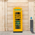 A yellow telephone box housing a defibrillator