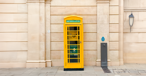 A yellow telephone box housing a defibrillator