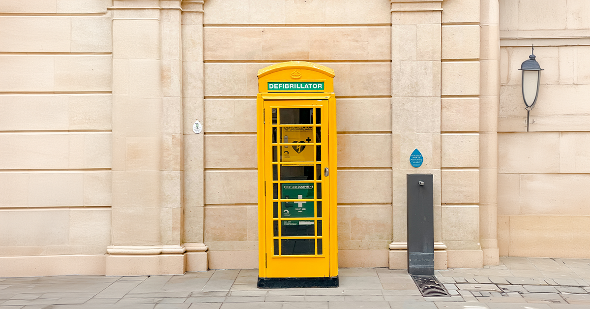 A yellow telephone box housing a defibrillator
