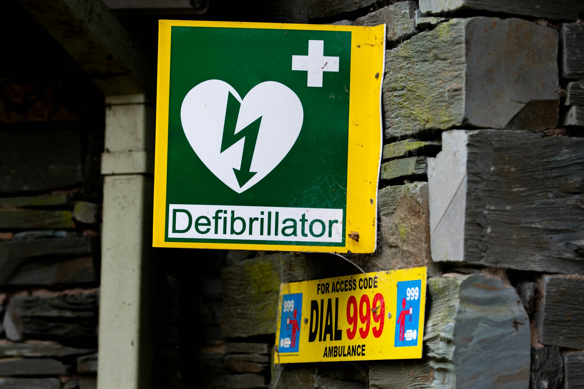 An image of a sign on a wall indicating that there is a defibrillator available for use